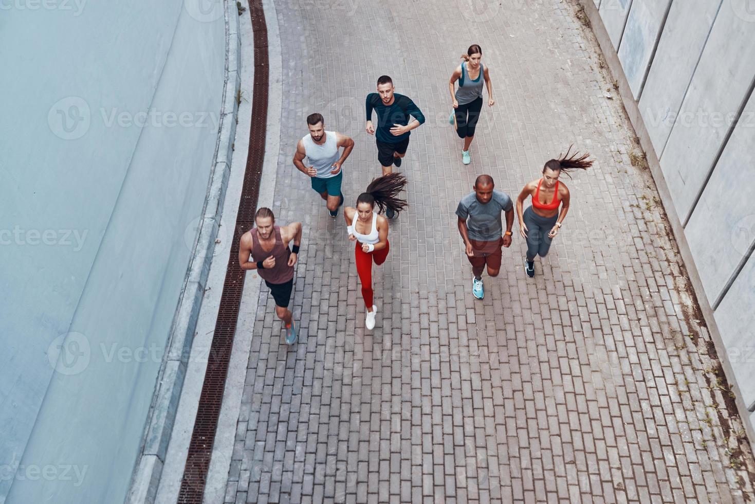 Top view of young people in sports clothing jogging while exercising outdoors photo