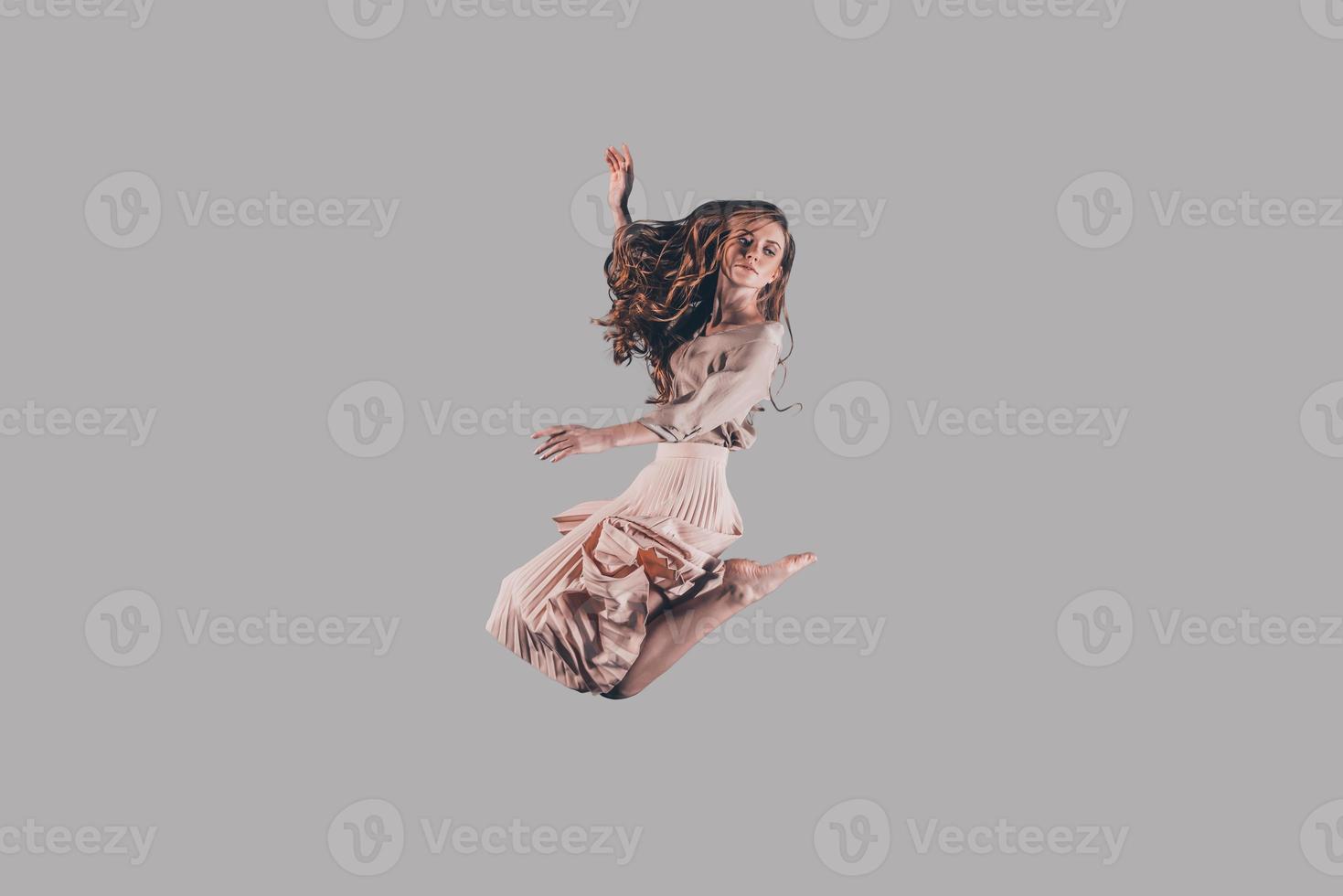 Moving free. Studio shot of attractive young woman hovering in air photo