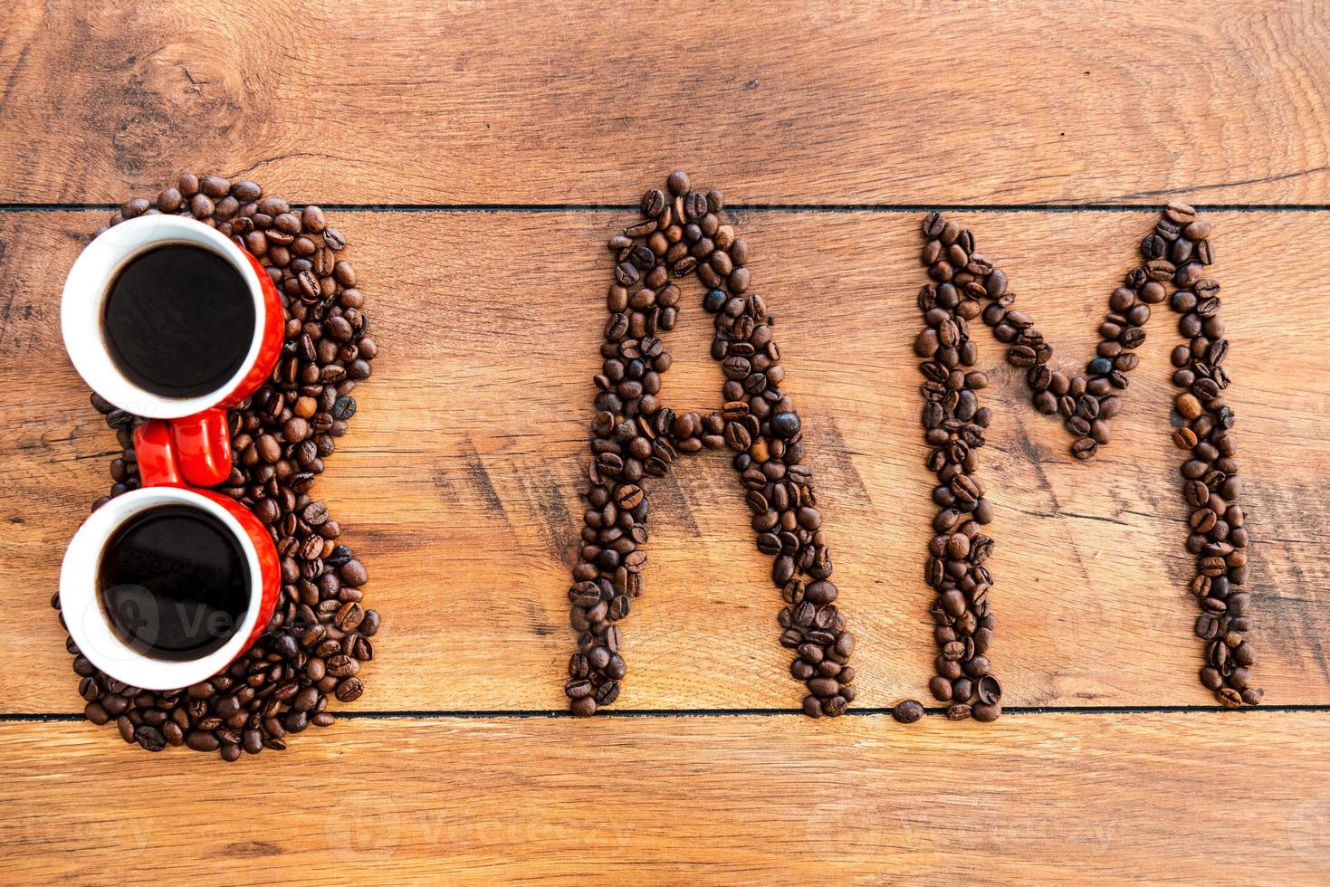 Start your morning with fresh coffee. Top view of number and letters made from coffee beans laying on the wooden desk photo