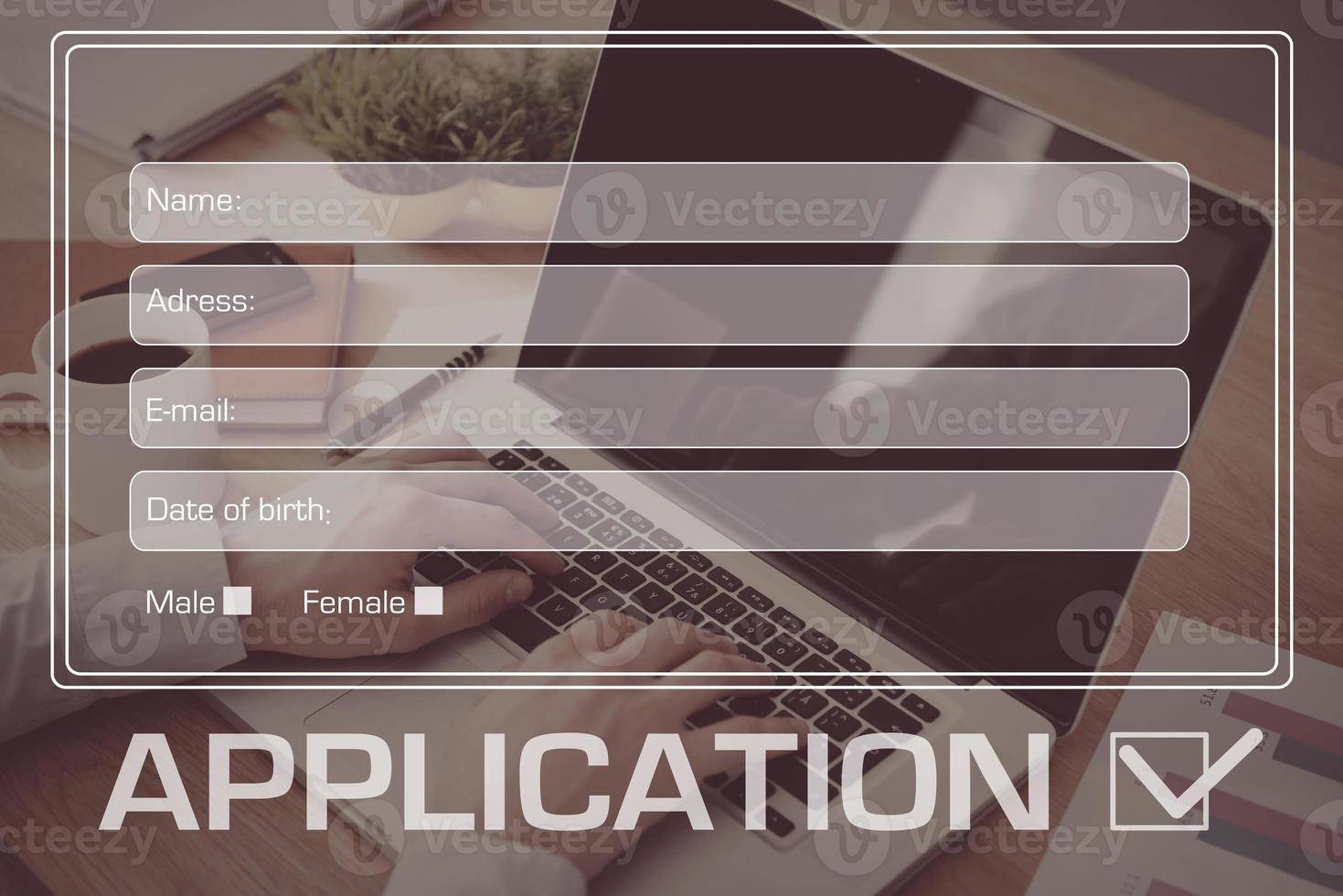 Apply online. Close-up top view of man working on laptop with digitally composed application form over it photo