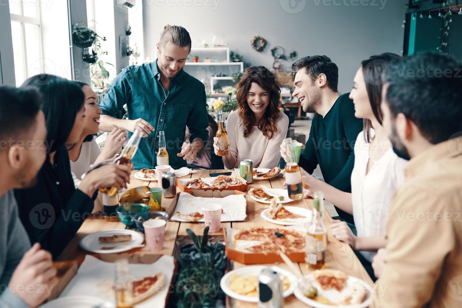 Real friendship. Group of young people in casual wear smiling while having a dinner party indoors photo