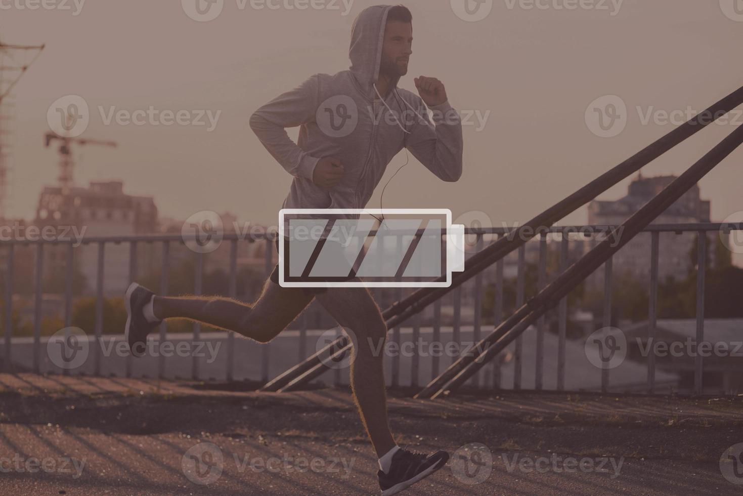 Full energy. Digitally composed picture of full charged battery symbol over picture of the jogger photo