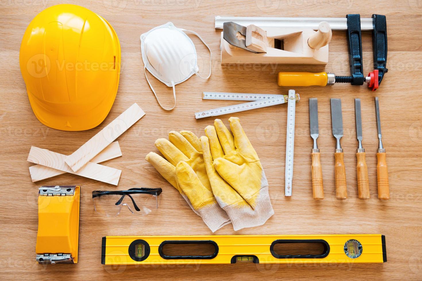 Work tools for carpenter. Top view of diverse working tools for wood industry laying on the wood grain photo