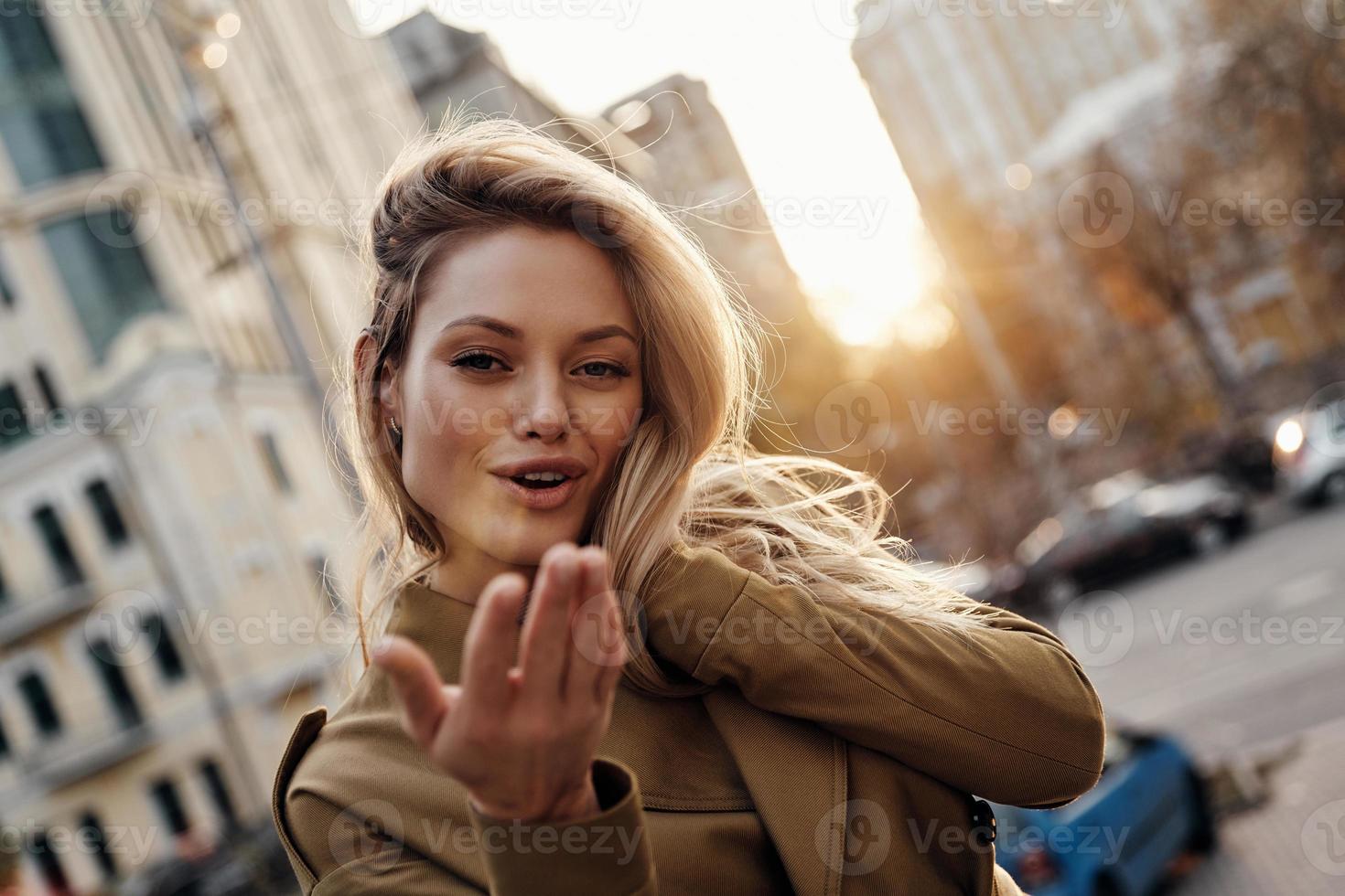 Soft sensuality. Attractive young woman looking at camera and smiling while standing outdoors photo