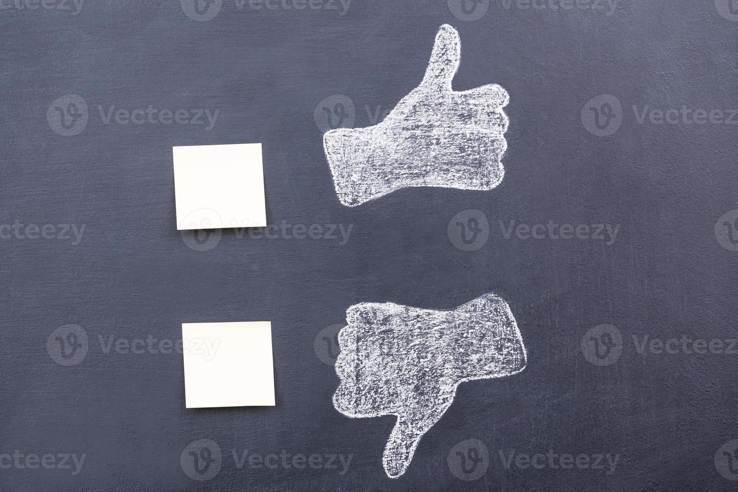 Yes or no Blackboard drawing of thumbs up and down with adhesive notes near them photo