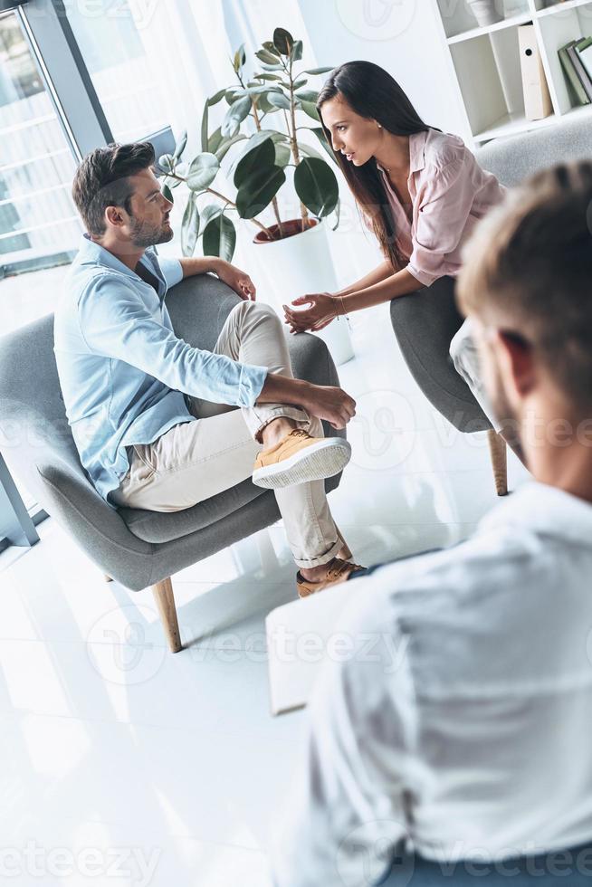 Every story has two sides. Young married couple talking while sitting on the therapy session with psychologist photo