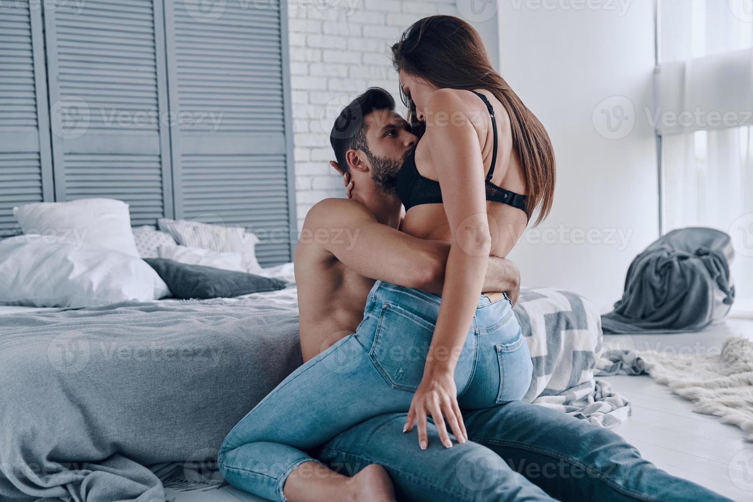 se está poniendo caliente hermosa joven pareja semi-vestida uniéndose mientras pasa tiempo en casa foto