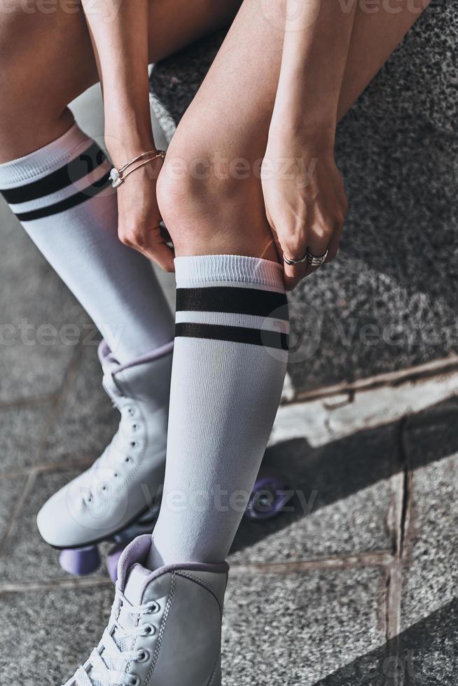 Paying attention to every detail. Close up of woman adjusting her knee sock while spending time outdoors photo