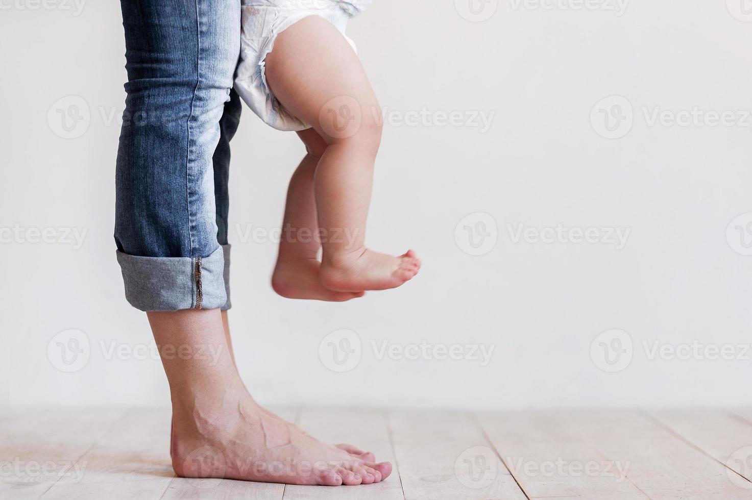 Ready for his first step. Cropped image of mother and baby legs photo