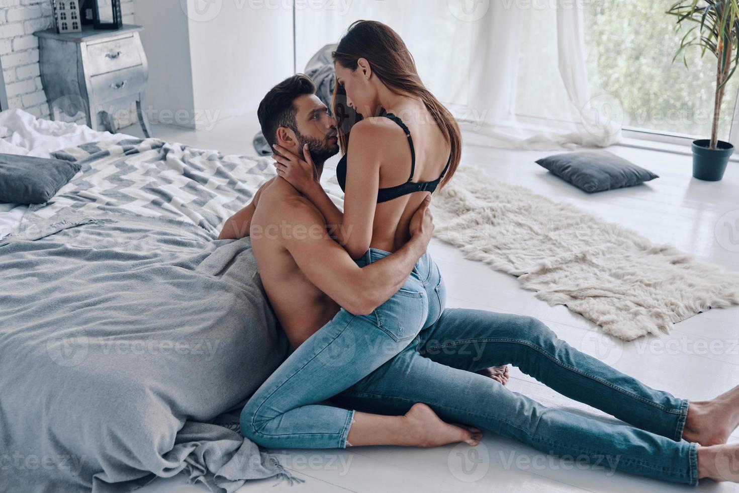 Intimacy. Beautiful young semi-dressed couple bonding while spending time at home photo