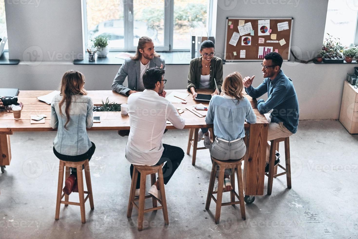 Discussing fresh ideas. Top view of modern young people working together while sitting in the office photo