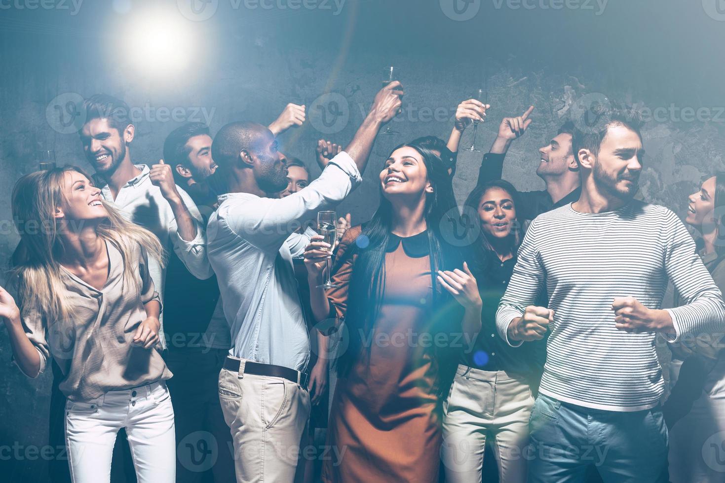 fiesta imparable. grupo de hermosos jóvenes bailando juntos y luciendo felices foto