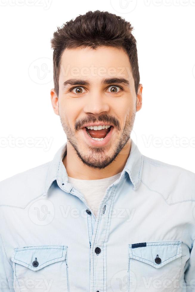 Unbelievable Portrait of surprised young man in shirt staring at camera while standing against white background photo