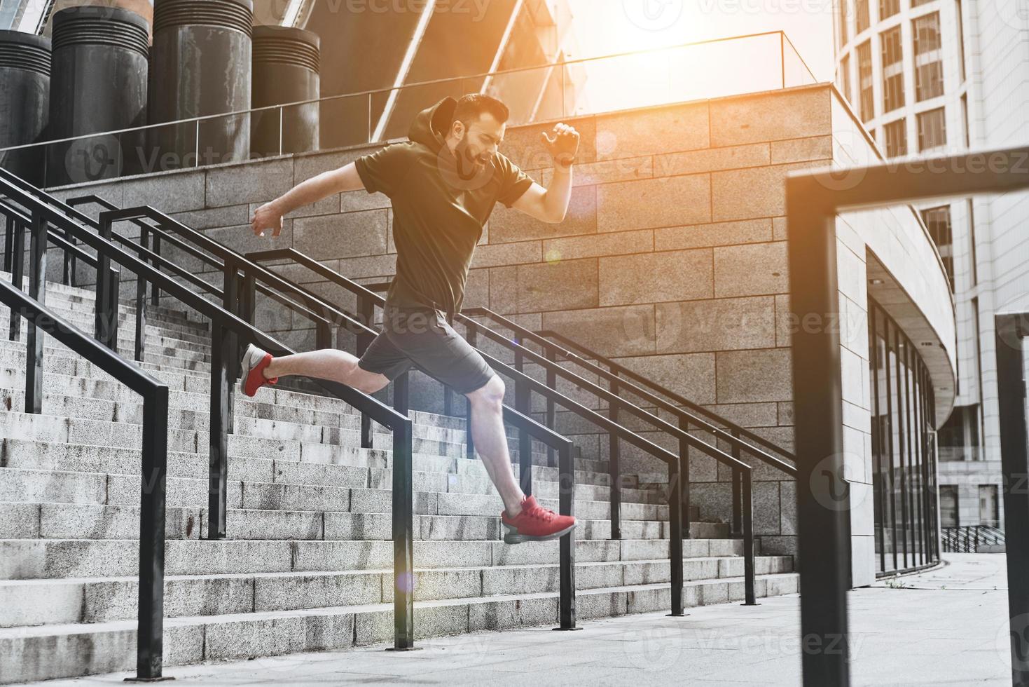 Making effort. Full length of handsome young man in sport clothing jumping while exercising outside photo
