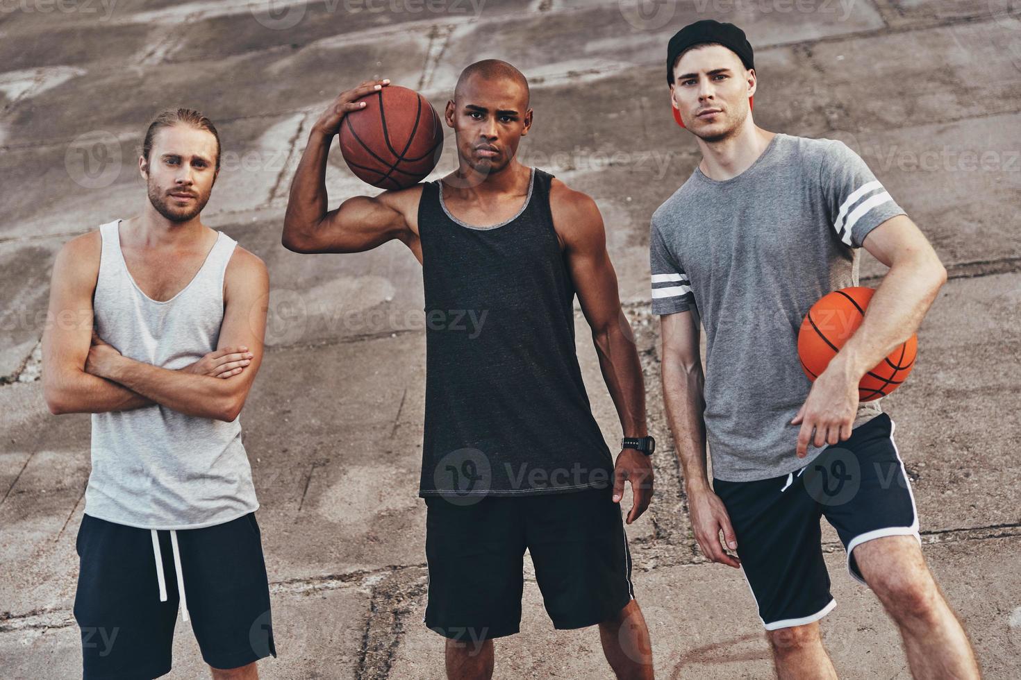 Sharing same hobby. Top view of young men in sports clothing looking at camera while standing outdoors photo