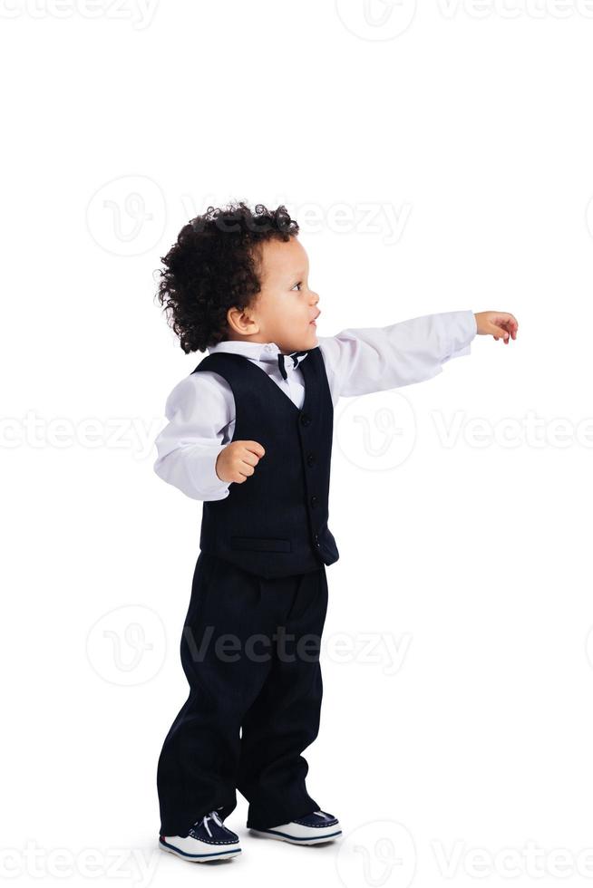 Take my hand Side view of little African baby boystretching out his hand and looking away while standing against white background photo