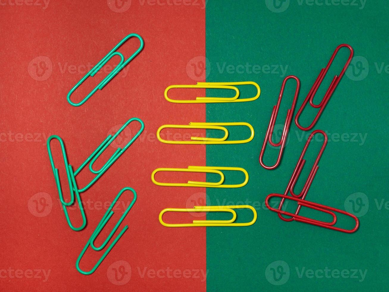 Colored paper clips on paper. Office supplies.   Colorful office supplies. photo