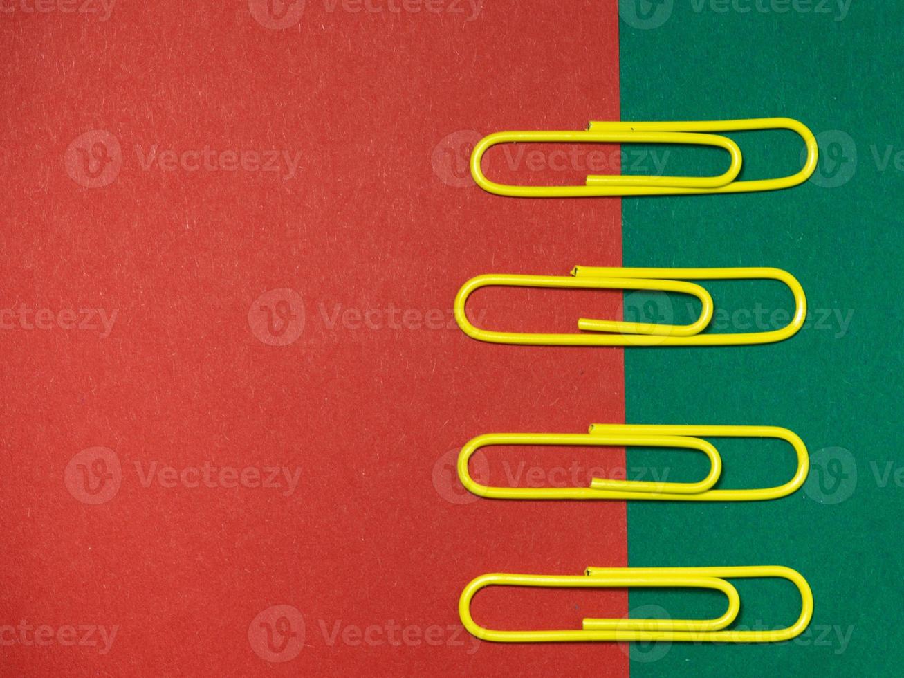 Colored paper clips on paper. Office supplies. Business goods. photo