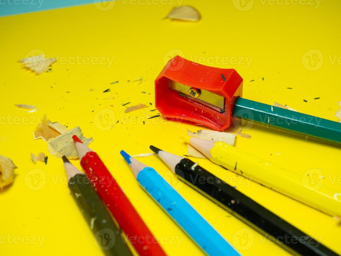 School supplies. Pencil sharpening.   Multicolored pencils. Wood shavings. The process of preparing for work. Creative mess photo