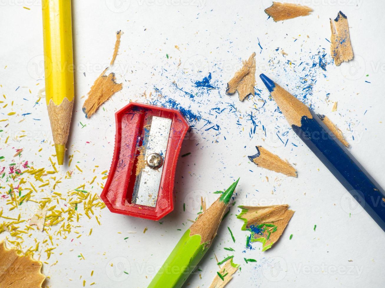 School supplies. Pencil sharpening.  Multicolored pencils on a white background. Wood shavings. The process of preparing for work. Creative mess photo