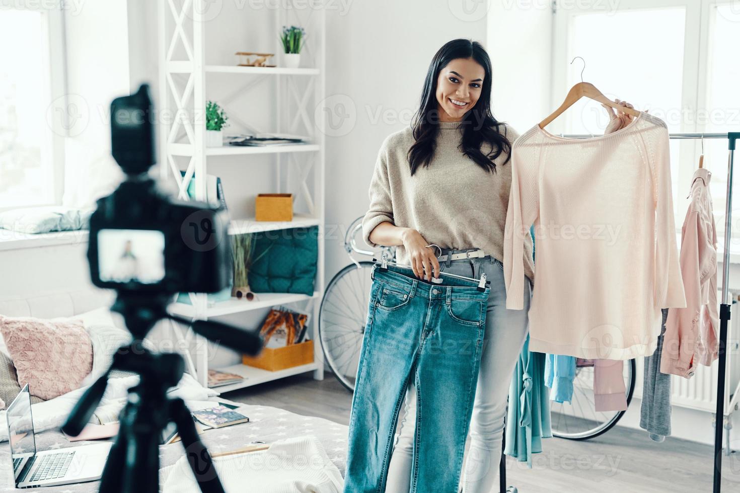 Beautiful young woman in casual clothing making social media video while spending time at home photo