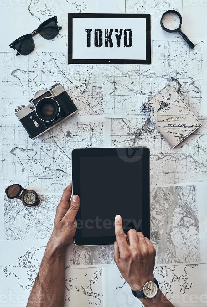 Tokyo. Close up top view of man using digital tablet in front of the map photo