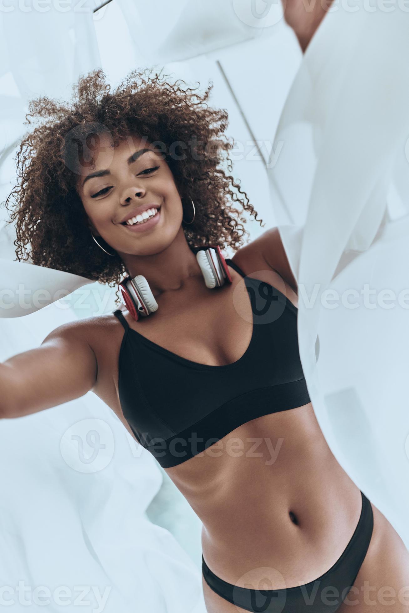 Beauty in bed. Top view close-up of beautiful young African woman in black  lingerie lying in bed and looking at camera 13576603 Stock Photo at Vecteezy