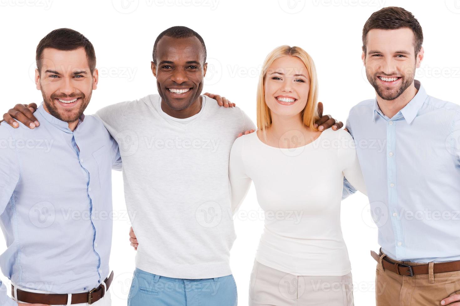 Happy business team. Four happy young people in smart casual wear looking at camera while bonding to each other and standing against white background photo