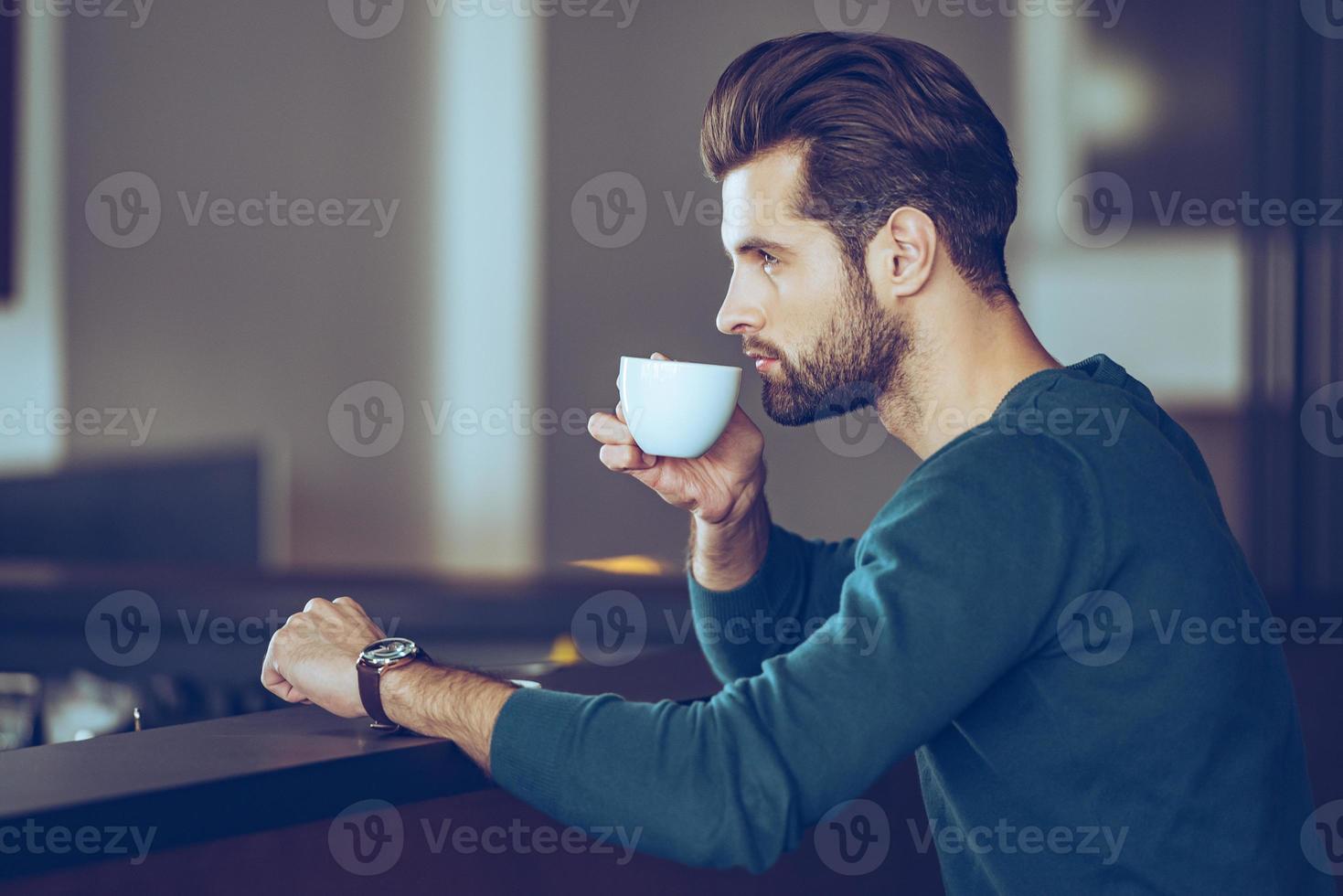 Nothing better then cup of fresh espresso. Side view of handsome young