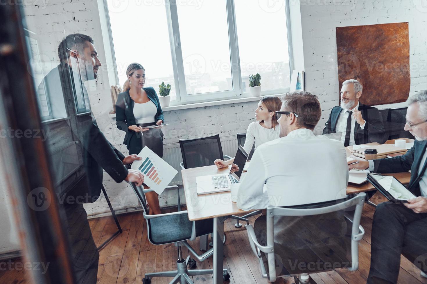 equipo de negocios exitoso que analiza las ventas mientras se reúne el personal en la sala de juntas foto