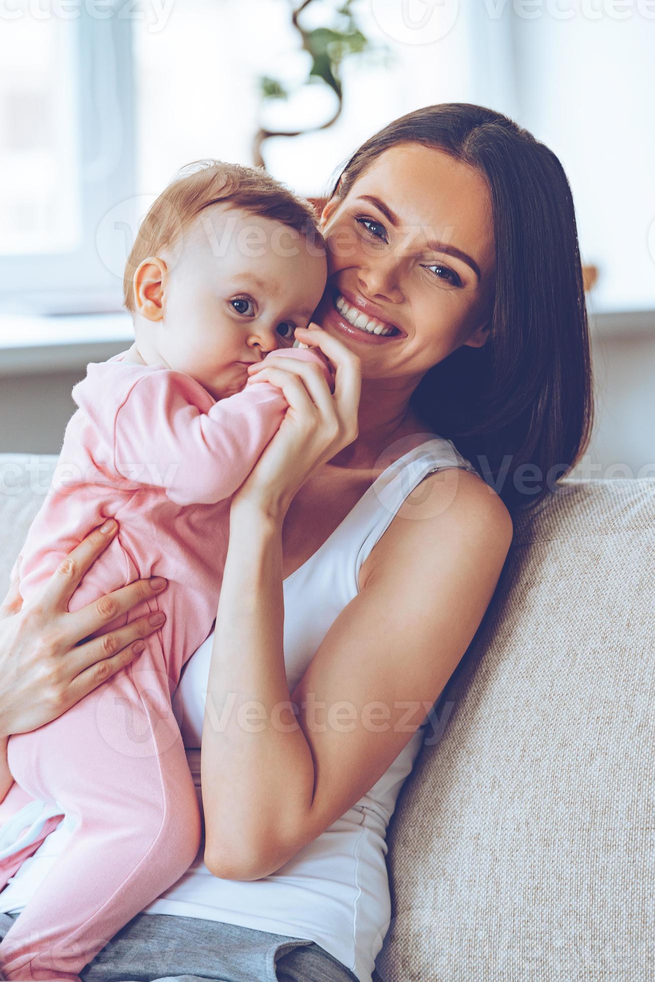Best hug ever. Cheerful beautiful young woman holding baby girl in her ...
