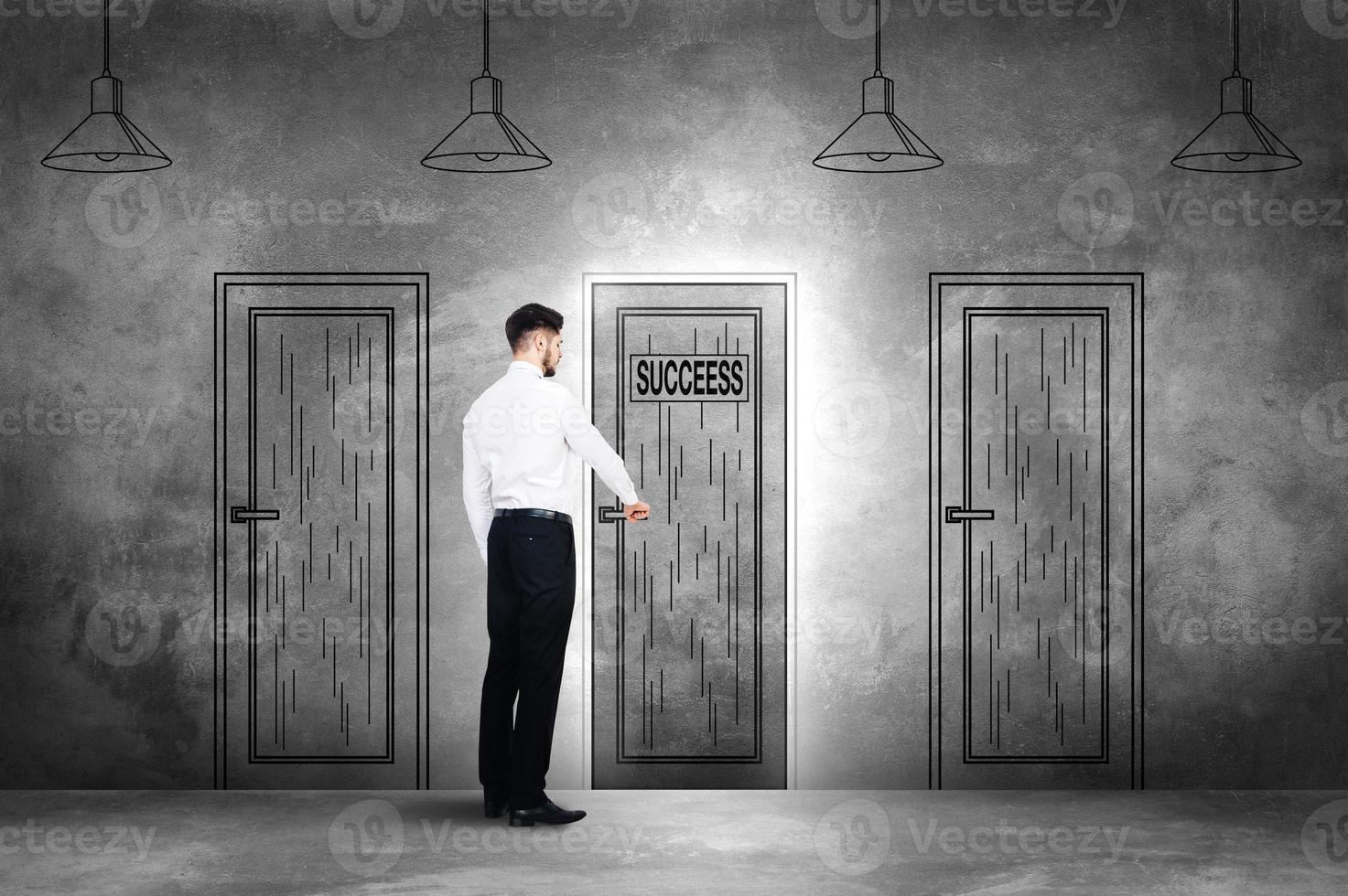Choosing success. Rear view of young man in formalwear openning an illustrated door on the concrete wall photo