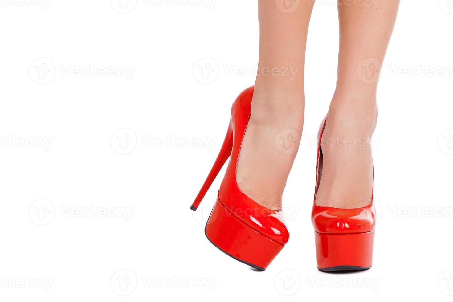 High heeled elegance. Close-up of beautiful female legs in red high heeled shoes isolated on white background photo