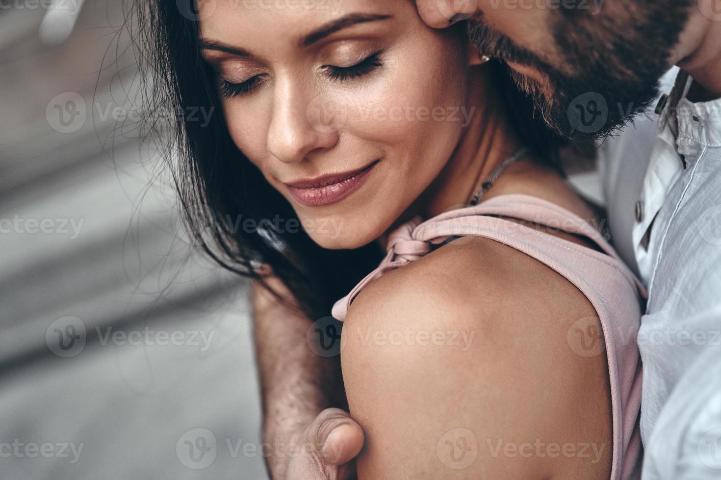 Moments of intimacy. Handsome young man embracing his beautiful girlfriend while spending time together in the city photo