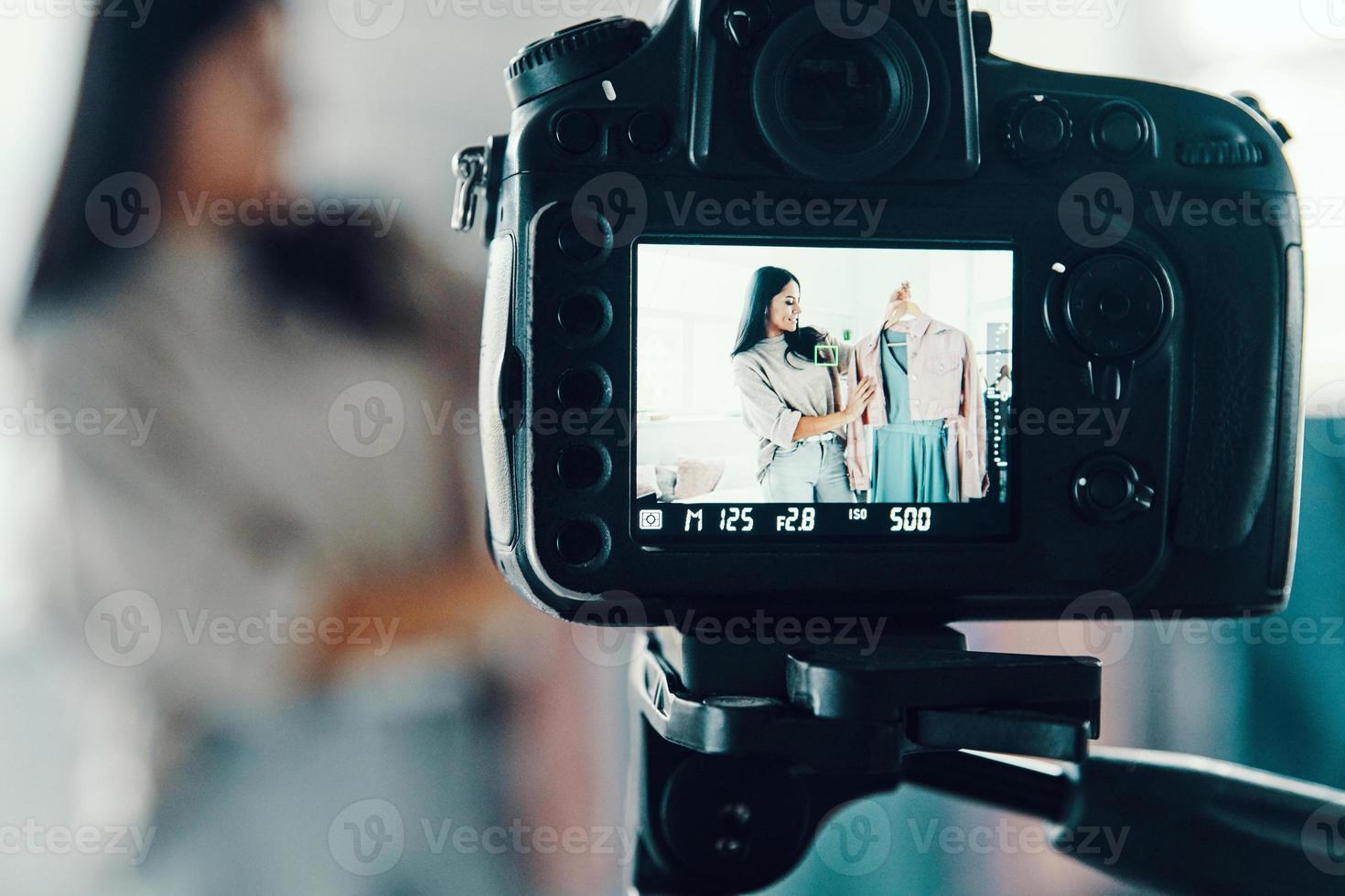 Beautiful young woman in casual clothing making social media video while spending time at home photo