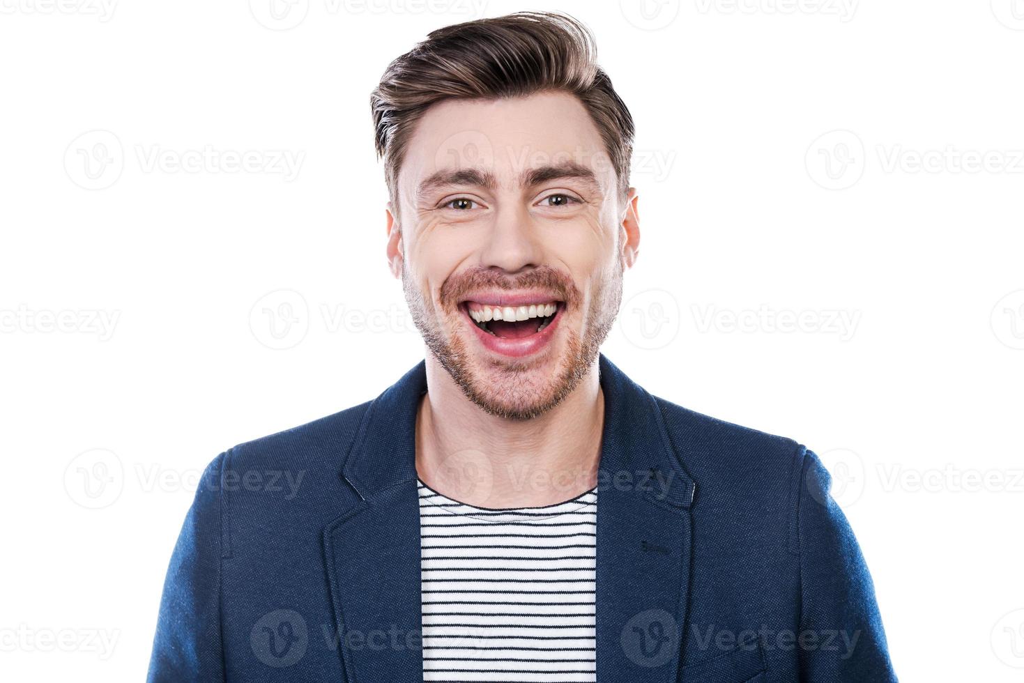 I am so happy Portrait of happy young man looking at camera and smiling while standing against white background photo