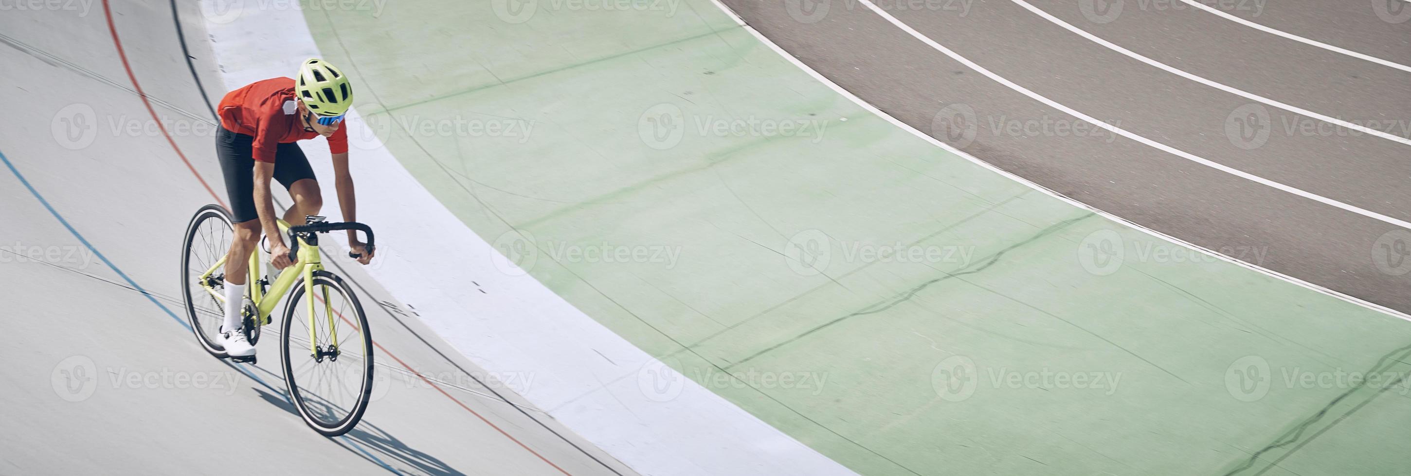 Top view of man in sports clothing cycling on track outdoors photo