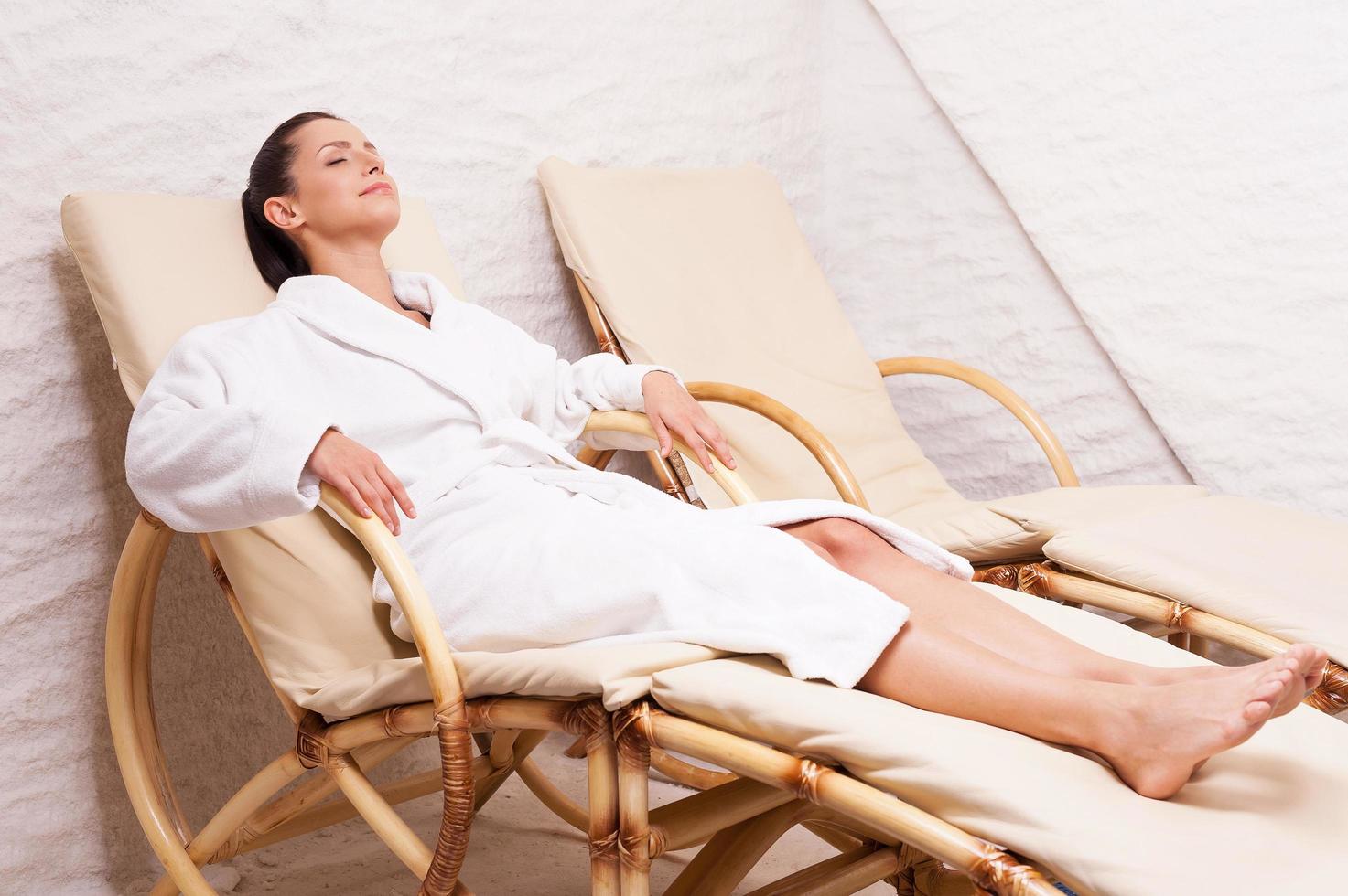 Woman in salt room. Beautiful young woman in bathrobe relaxing in salt room photo