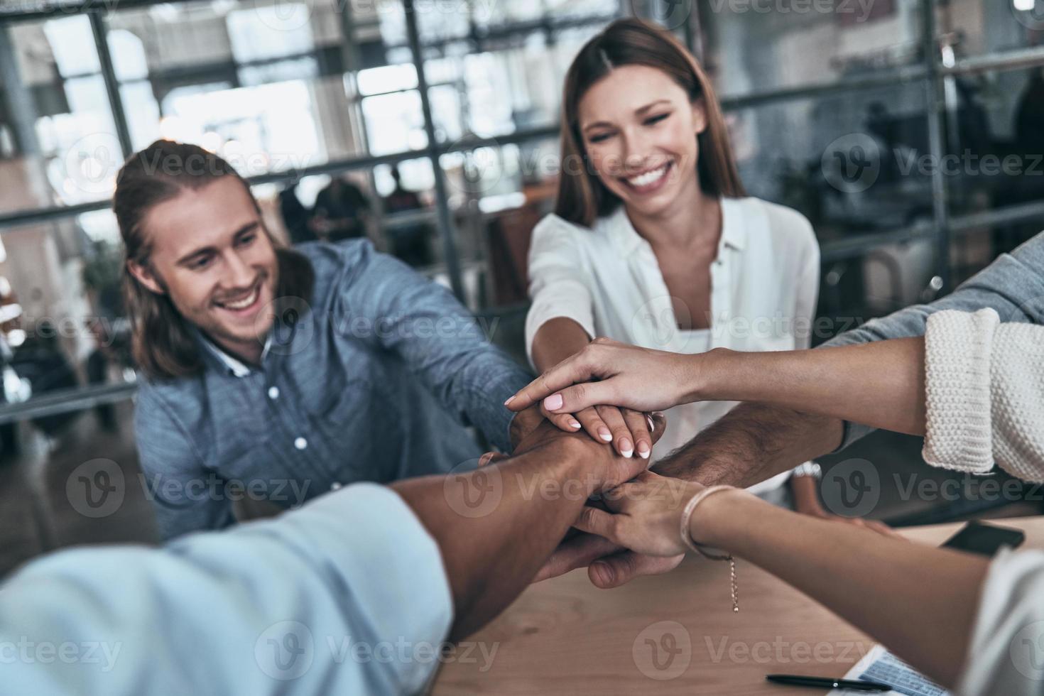 Best team. Top view of business colleagues holding hands on top of one another in a symbol of unity while working in the board room photo