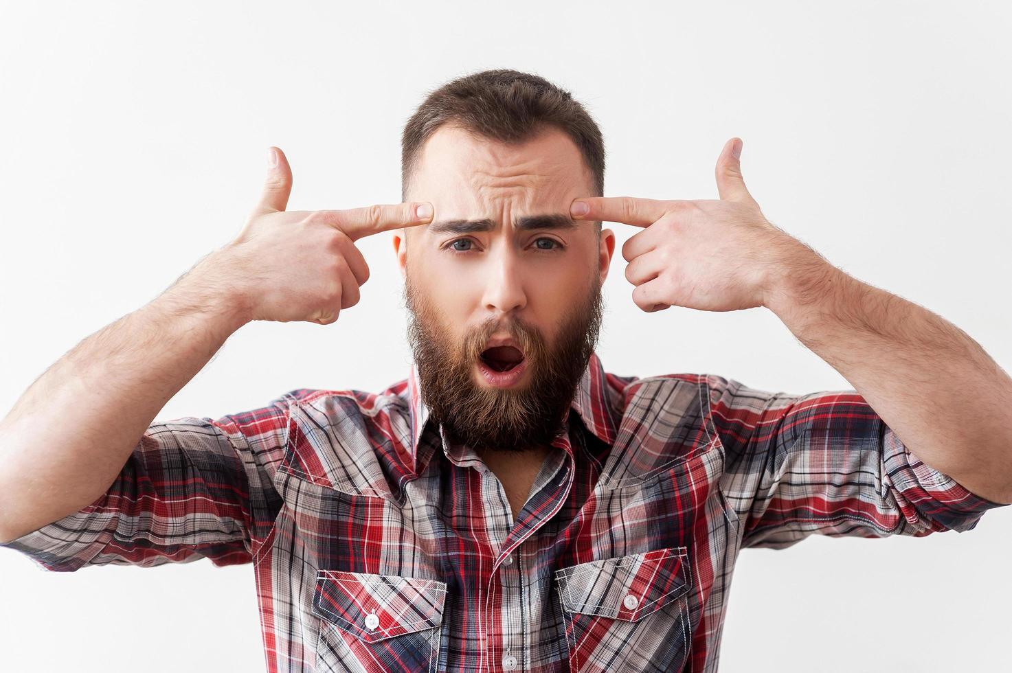 Monday morning suicide. Frustrated young man in casual wear touching his temple with finger gun photo