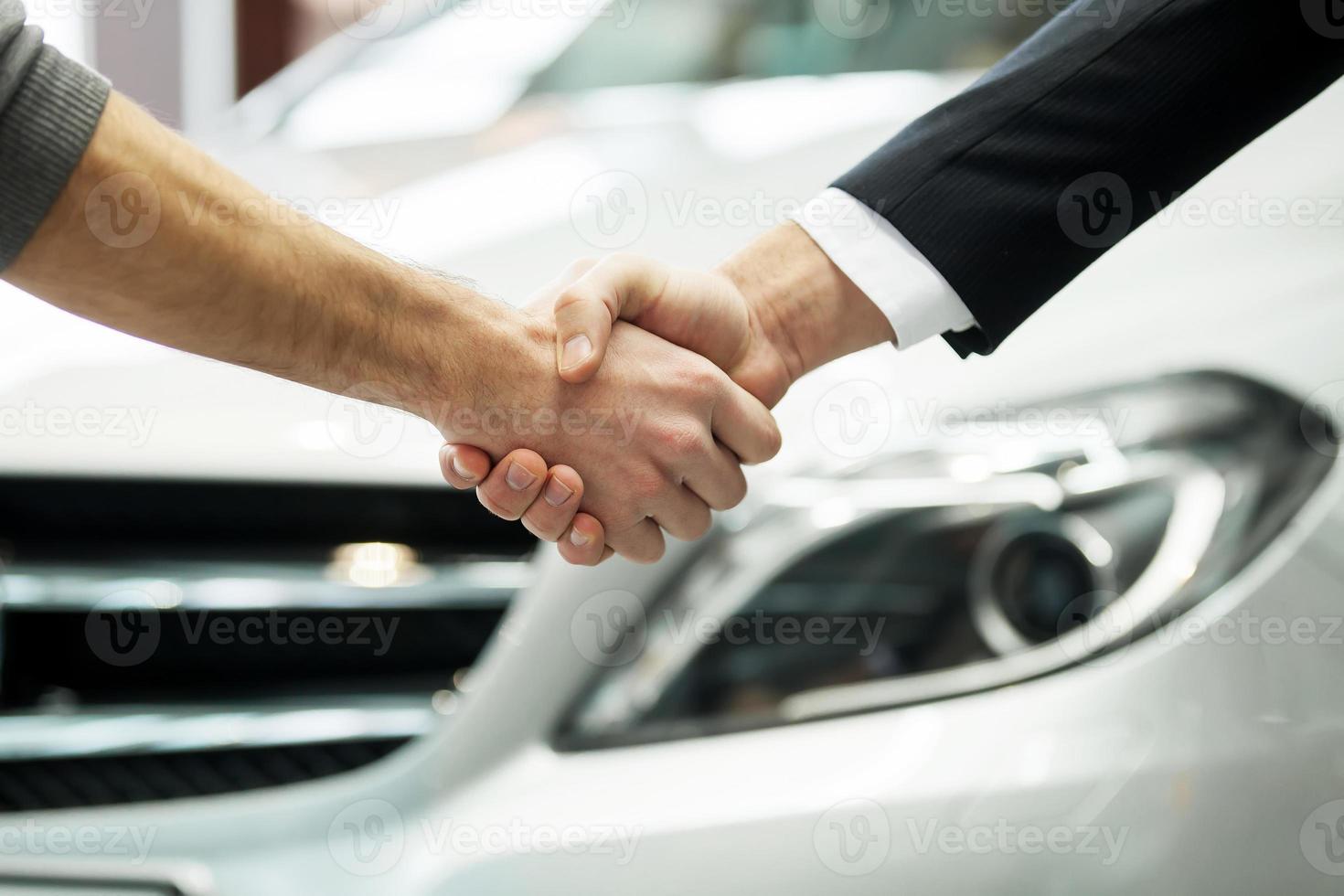 buen negocio. toma de primer plano de las manos temblando frente al auto foto