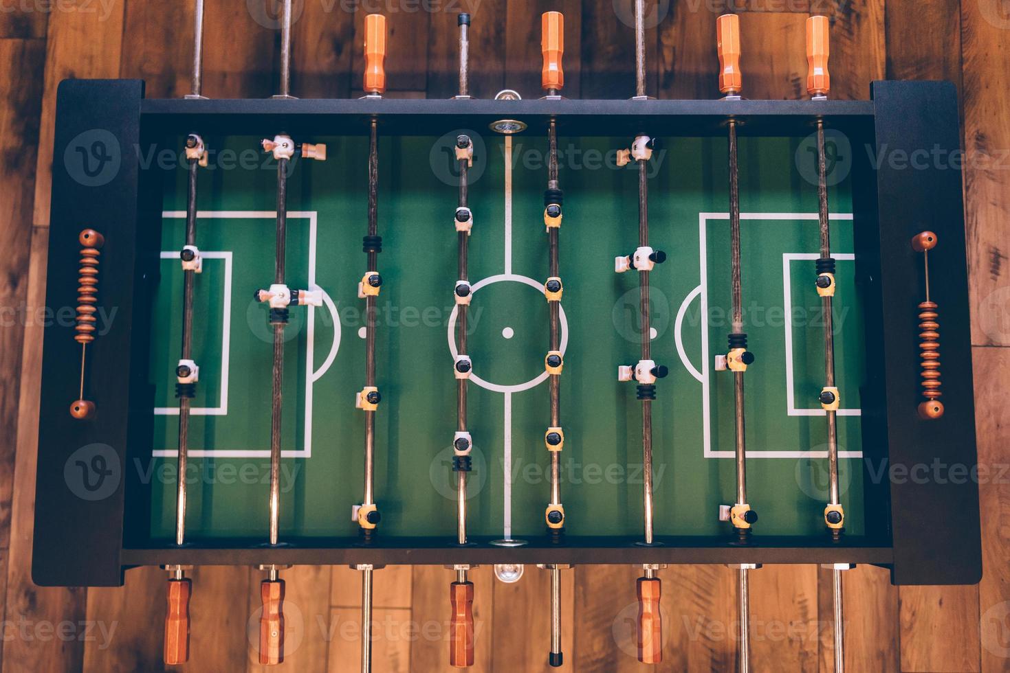 Foosball table. Top view of foosball table on the wooden floor photo