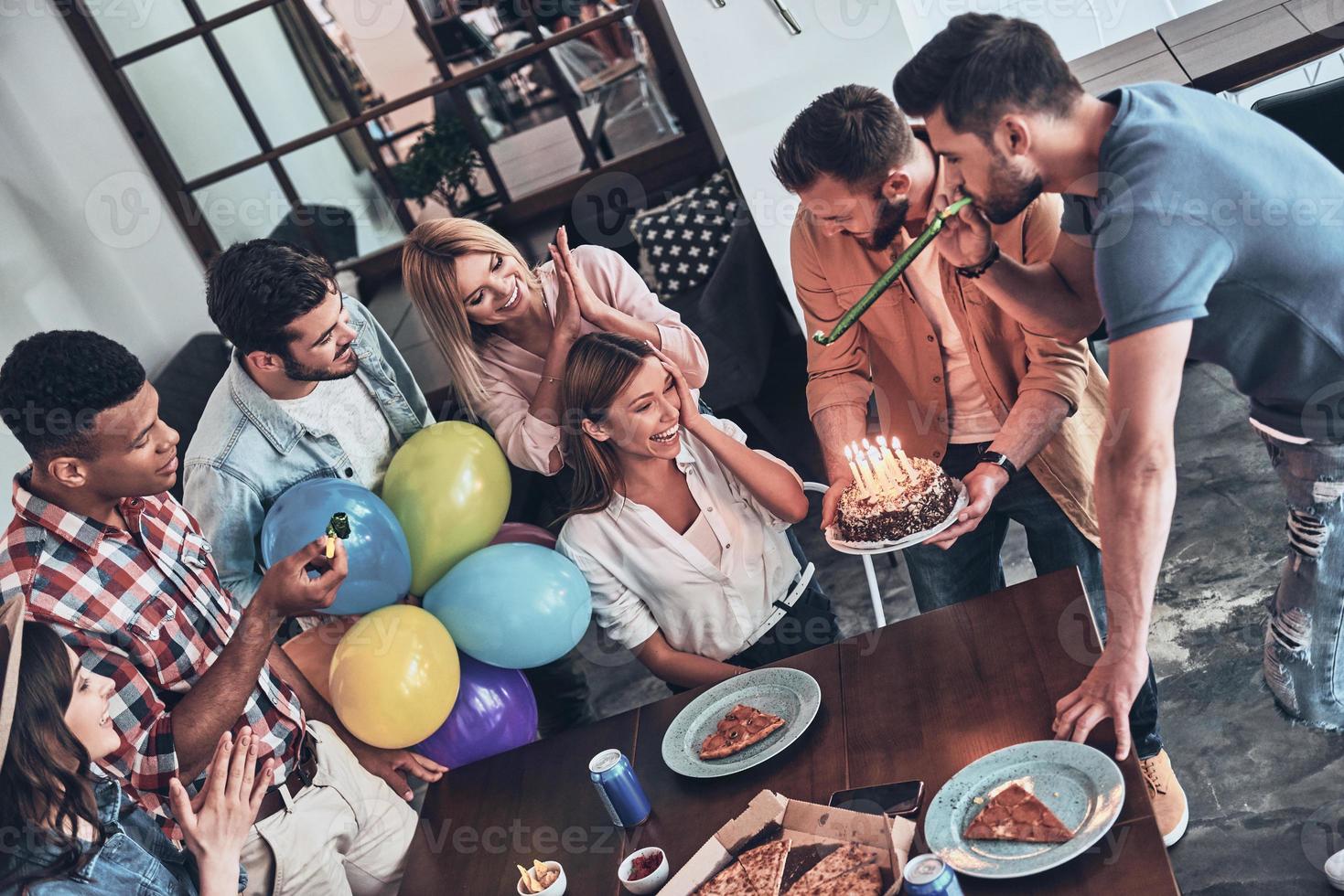 Ready to blow the candles Top view of happy people celebrating birthday among friends and smiling while enjoying a party photo