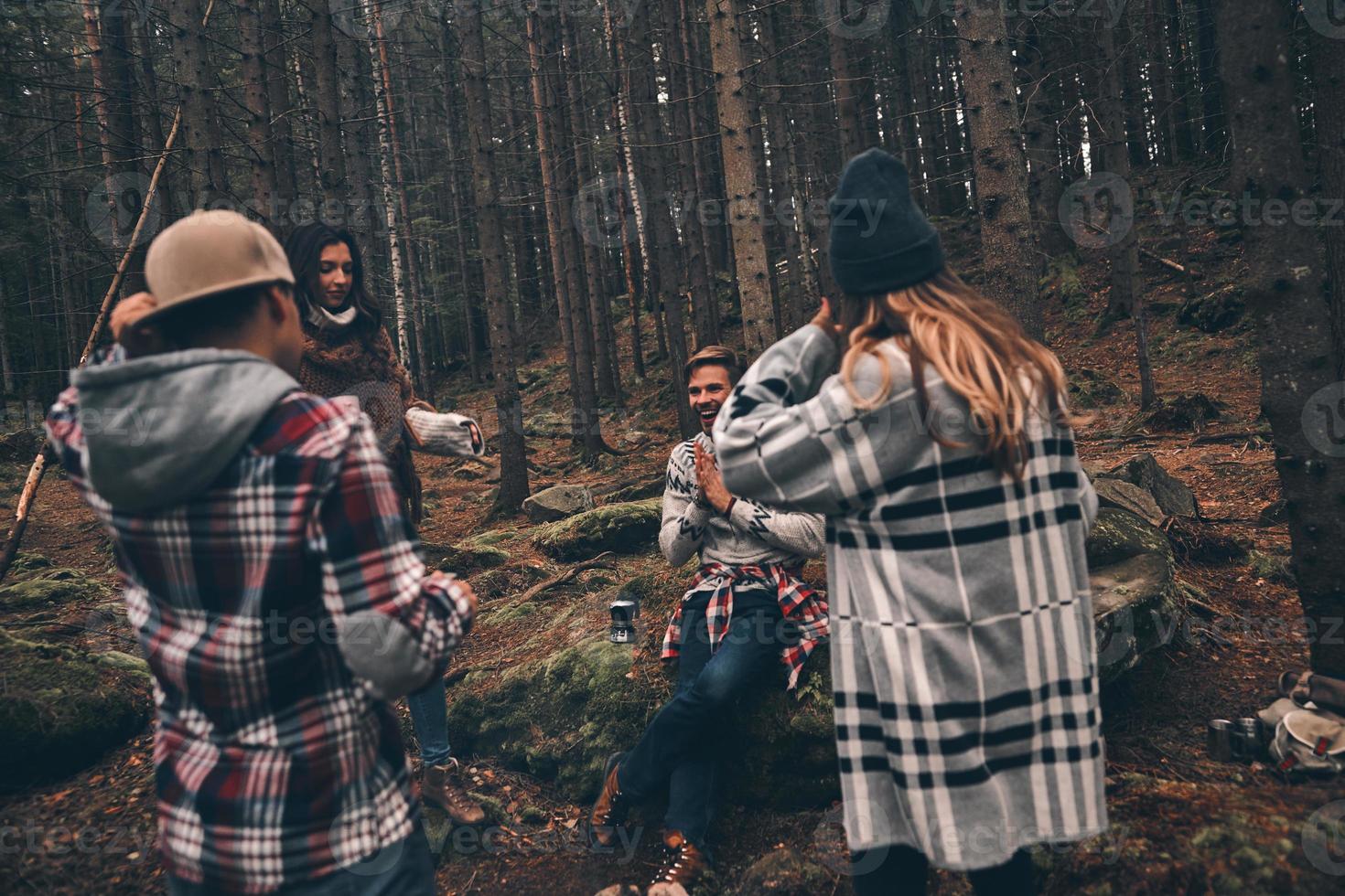 Nothing is better than old friends. Group of happy young people spending time together while hiking in the woods photo