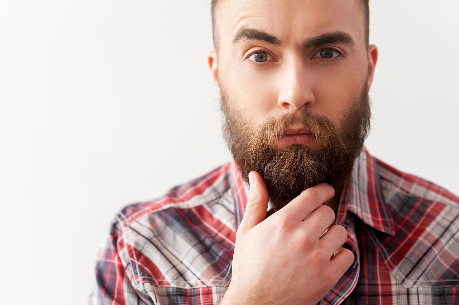 Bearded inspector. Portrait of handsome bearded young man with hand on chin photo