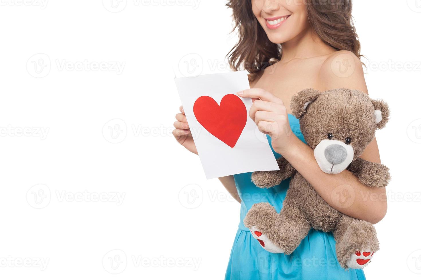 chica con tarjeta de San Valentín. imagen recortada de una hermosa joven leyendo una tarjeta de San Valentín mientras se encuentra aislada en el fondo blanco foto