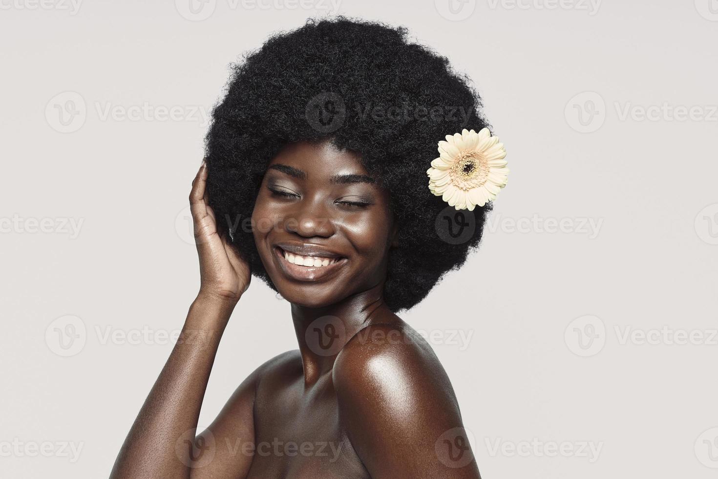 Portrait of beautiful young African woman keeping eyes closed and smiling photo