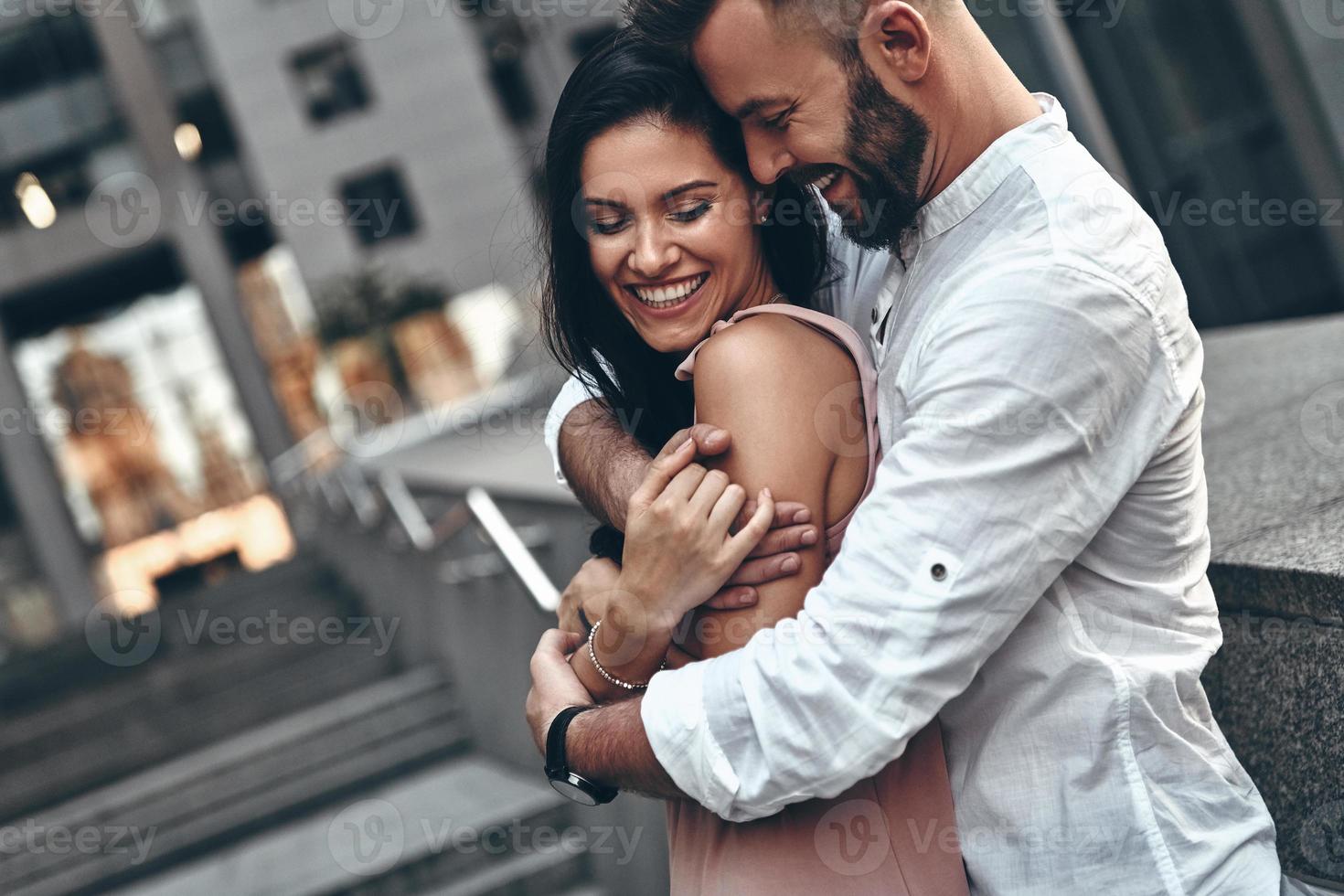 Love is in the air. Handsome young man embracing his beautiful girlfriend while spending time together in the city photo