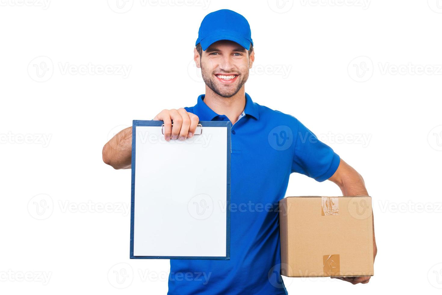 Copy space on his clipboard. Cheerful young courier stretching out clipboard and smiling while standing against white background photo