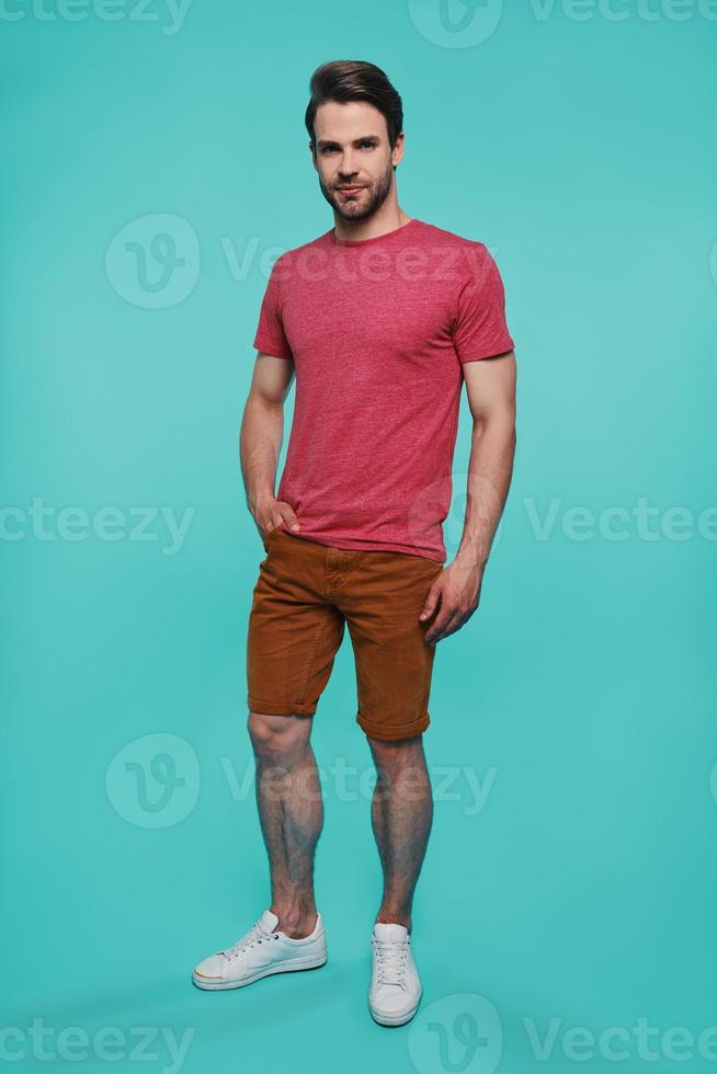 Full length of handsome young man in casual clothing looking at camera photo